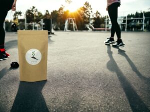 Erlebe die Leichtigkeit des Seins mit unserem AY Natural Doypack der auf dem Boden ruht und mit speziellem Tee gefüllt ist der dazu beiträgt Gewicht zu verlieren Die Atmosphäre dieses Bildes strahlt Freude und Lebendigkeit aus und ermutigt dazu den Genuss und die Vorteile unseres Gewichtsabnahme Tees in vollen Zügen zu erleben