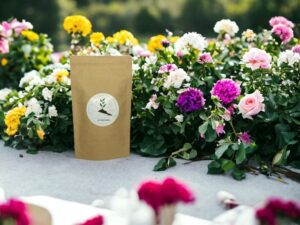 Dieses Bild zeigt unseren AY Natural Doypack präsentiert auf einem Tisch mit einem romantischen Rosenstrauch im Hintergrund Unsere blumigen Teemischungen vereinen die subtilen Aromen von verschiedenen Blüten zu einer harmonischen und aromatischen Erfahrung